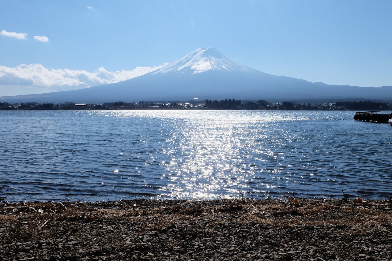 Scenic view of Mount Fuji over Kawaguchi Lake with clear skies and serene waters, perfect for travel inspiration.